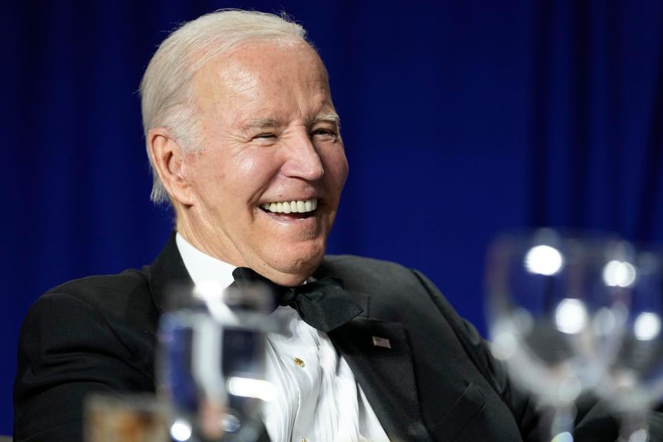 President Joe Biden laughs while listening to White House Correspondents' Dinner host Roy Wood Jr., who made quips about Tucker Carlson and Don Lemon.